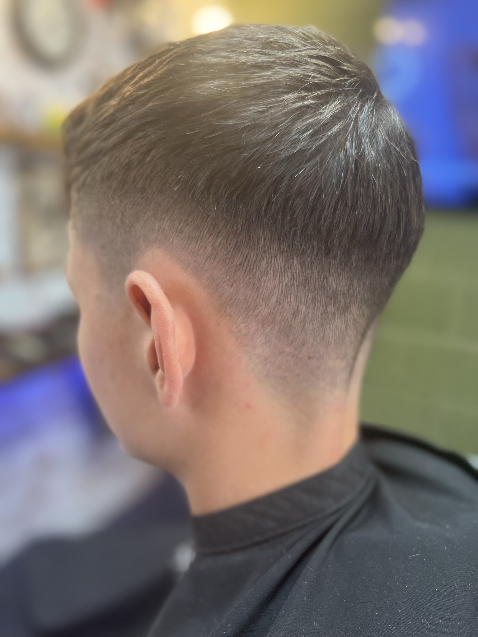 A taper fade from behind, at the shop