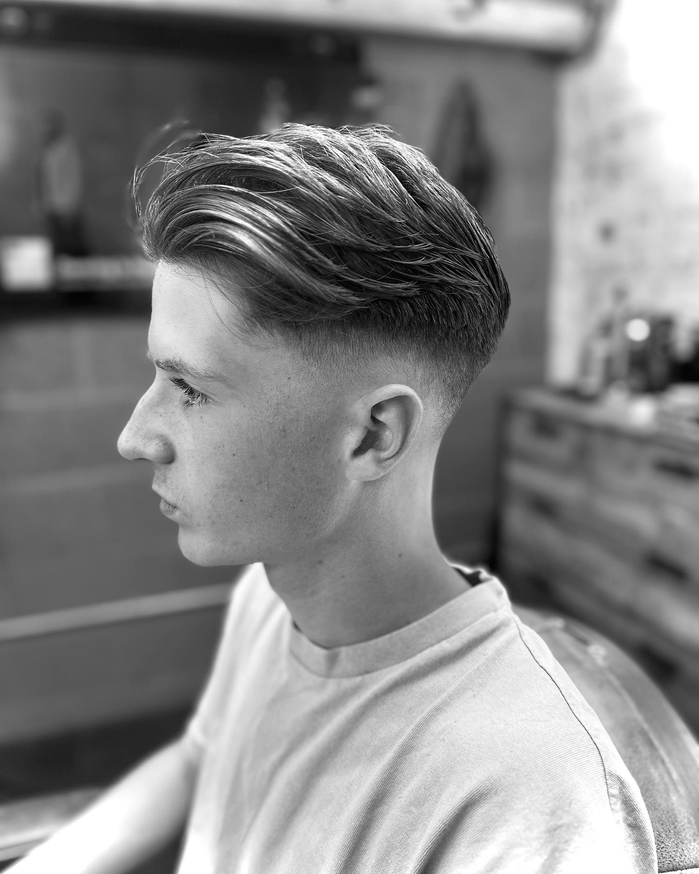 Black and white side profile of a swept back cut with a fade
