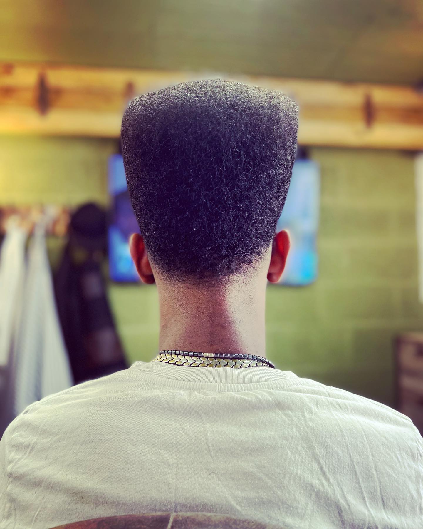 A high top on afro hair with a clean neckline, from behind