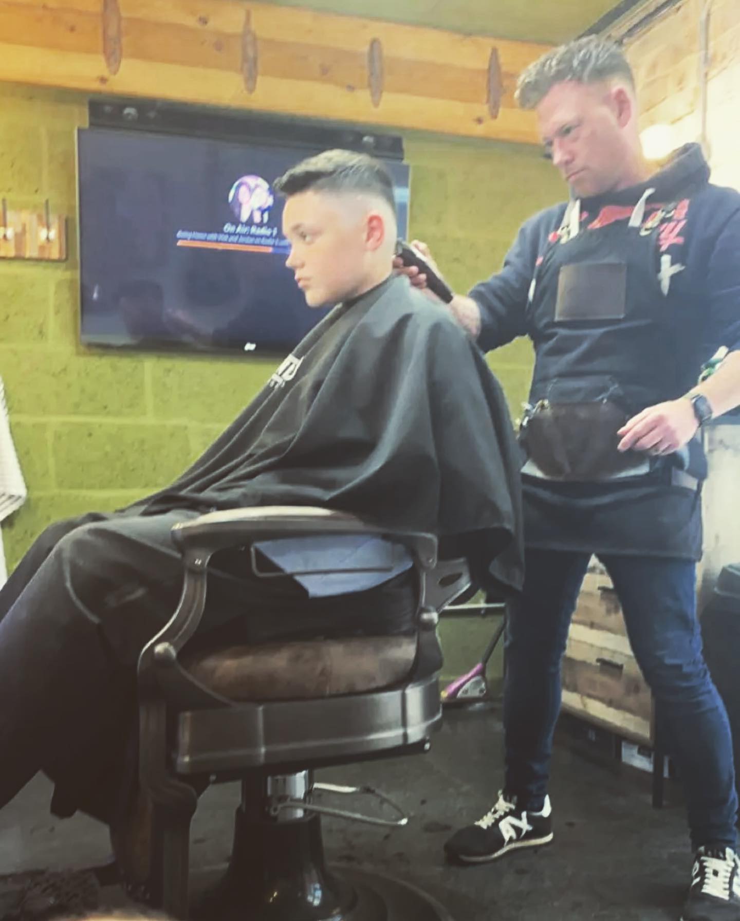 Dion cutting a young client's hair with clippers at Studio G